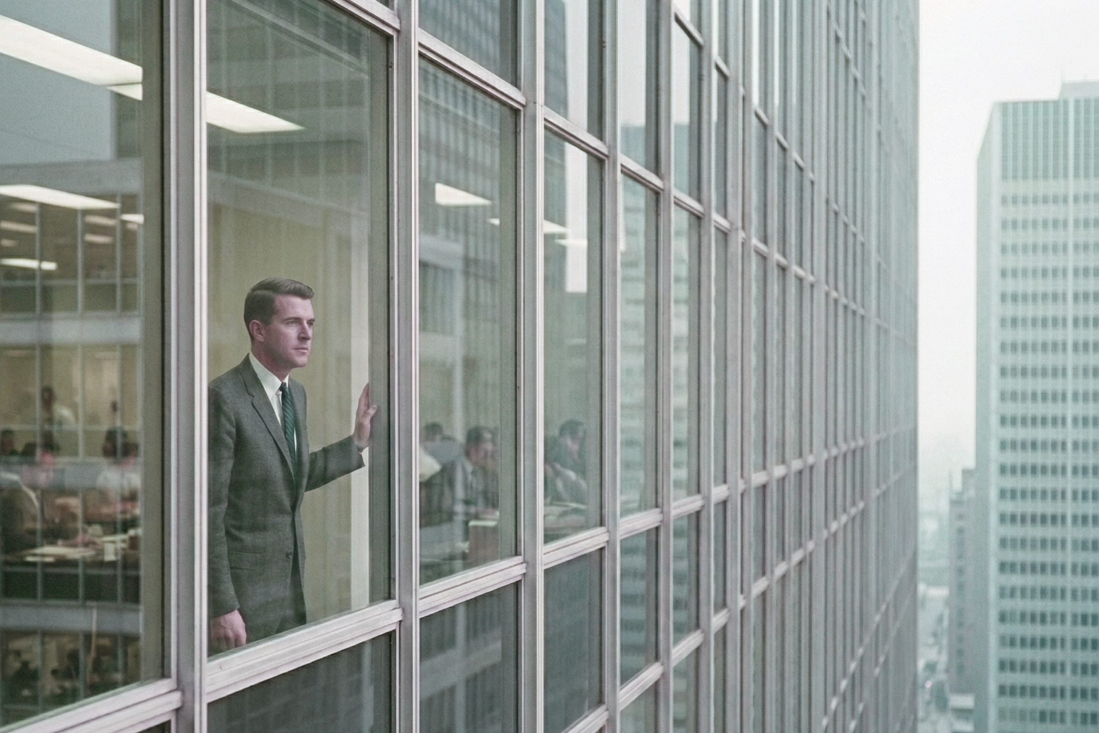 Soulless corporate-ness A worker stares out the window of an International Style skyscraper