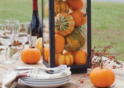 Decorative gourds in a glass case on a wooden table
