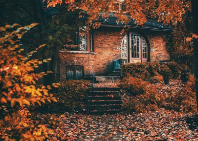 Brick house with fall leaves around it