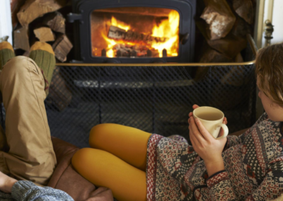 Two people sitting by a fireplace