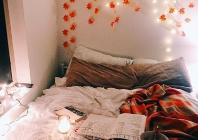 Fall leaves over a bed with lit candle
