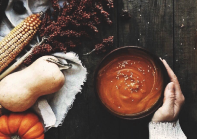 Overhead shot of hearty fall soup with gourds next to it
