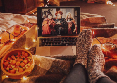 Hocus Pocus movie on a laptop with lights and blanket