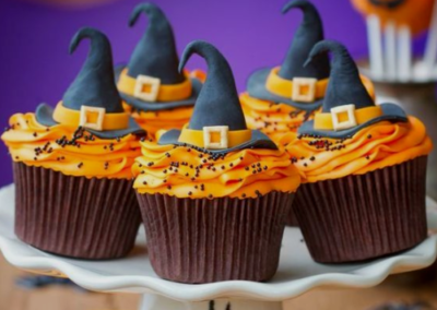 Orange cupcakes with witch hats on top of them