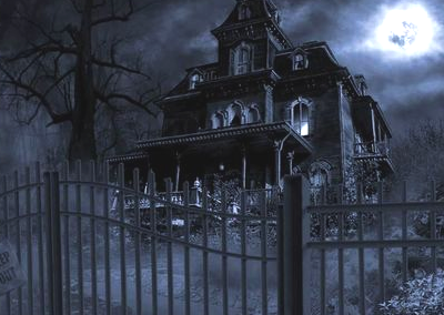 A Victorian house at night in the moonlight standing behind a fence