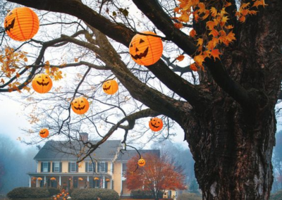Halloween lanterns in a tree with a country house in the background